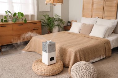 Modern hava nemlendirici, şık bir yatak odasında pouf 'ta.