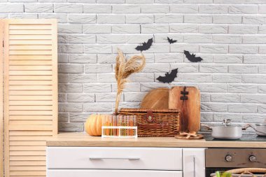 Mutfaktaki gri tuğla duvardaki kağıt yarasalar Cadılar Bayramı için dekore edilmiş.
