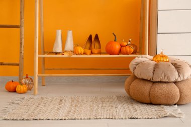 Balkabaklı ayakkabılar ve sonbahar yaprakları salonda.