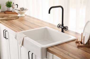 Güzel mutfağın penceresinin yanındaki ahşap tezgahta lavabo