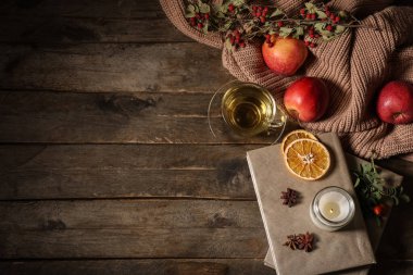 Sonbahar kompozisyonu, bir fincan yeşil çay, defterler ve ahşap zemin üzerine kazak.