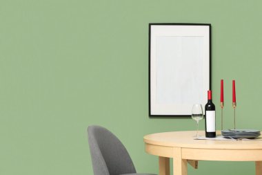 Yemek odasında mum ve şarap olan bir masa.