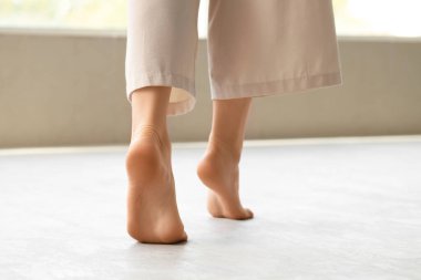 Düz tabanlı genç bir kadın. Evinde, arka manzaralı.