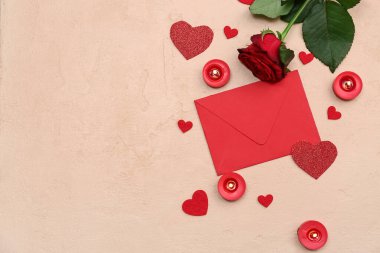 Çiçekli mumlar ve bej arka planda Sevgililer Günü kutlamaları için zarf.