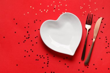 Kırmızı arka planda konfeti olan güzel bir masa. Sevgililer Günü kutlaması