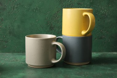 Yeşil arkaplanda seramik bardaklarla kompozisyon