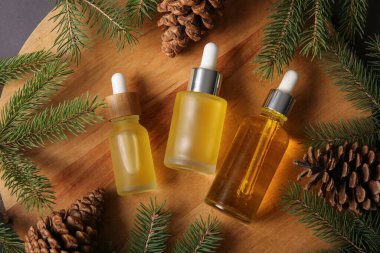 Kozalaklı şişeler ahşap tahtada gerekli yağ.