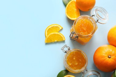 Açık mavi arkaplanda lezzetli turuncu reçel kavanozları