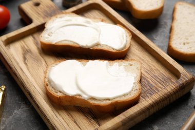 Siyah arka planda işlenmiş peynirli lezzetli bruschetta kesme tahtası. Yakın çekim.