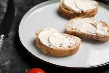 Siyah arka planda işlenmiş peynirli lezzetli bruschetta tabağı, yakın plan.