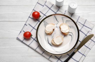 İşlenmiş peynirli lezzetli bruschetta tabağı ve beyaz ahşap arka planda taze domatesler.