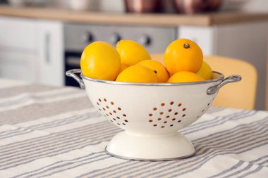Mutfaktaki yemek masasında limonlu Colander, yakın plan.