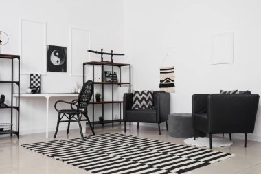 Siyah koltuklu, işyerli ve Yin Yang resimli ofis.