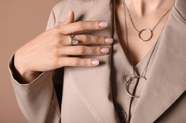 Gri yüzüklü ve kolyeli şık ceketli güzel bir bayan.