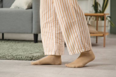 Pijamalı kadın bacakları ve evde ısıtmalı çoraplar.