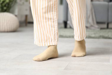 Pijamalı kadın bacakları ve evde ısıtmalı çoraplar.