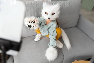 Kedi maskeli kız evde video kaydı yapıyor.