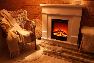 Geceleri şöminesi ve koltuğu olan bir oturma odası.