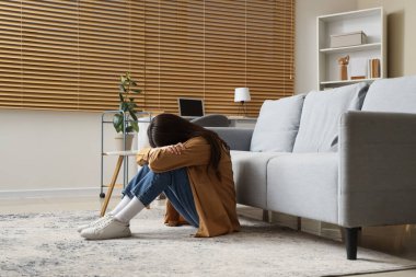 Evdeki endişeli genç kadının portresi.