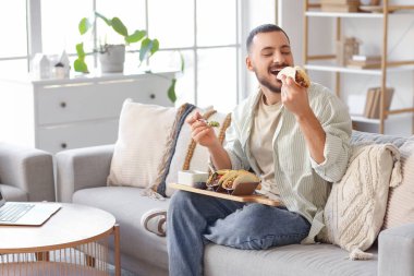 Genç adam evde lezzetli tacolar yiyor.