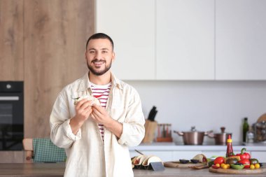 Mutfakta lezzetli Meksika taco 'su olan genç adam.