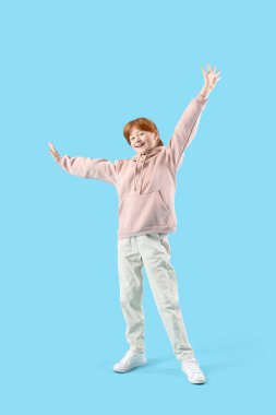 Mavi arka plandaki mutlu kızıl kız