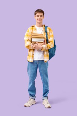 Okul çantalı ve eflatun arkaplanlı genç çocuk.