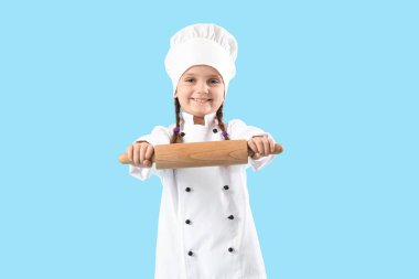 Mavi arka planda merdanesi olan sevimli bir aşçı.