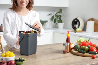 Mutfakta gübre kutusu olan genç bir kadın.