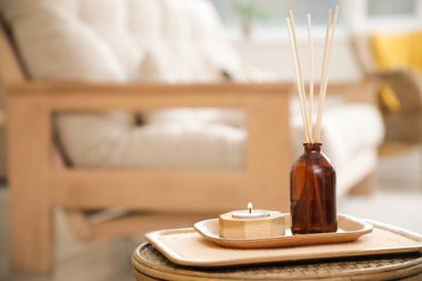 Reed dağıtıcı, oturma odasındaki masada yanan mum, yakın plan.