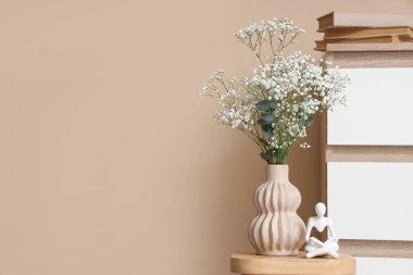 Odadaki çekmecelerin yanındaki sehpanın üzerinde çingene çiçekleri olan vazo. Yakın çekim.