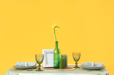 Sarı arka planda çiçekli restoran masası.