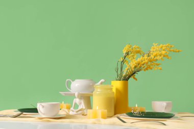 Yeşil arka planda çiçekler olan restoran masası.