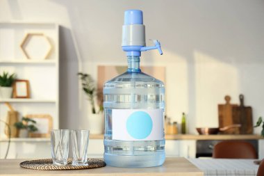 Mutfaktaki masada bardaklı bir şişe temiz su.