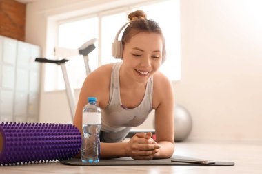 Sportif genç kadın spor salonunda kalas yapıyor.