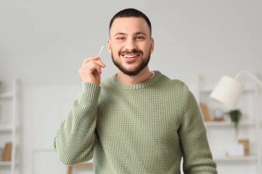 Evde pamuklu genç adam var.