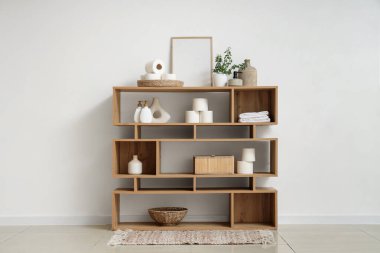 Tuvalet kağıdı ruloları ve kozmetik ürünleri banyodaki raf ünitesinde.