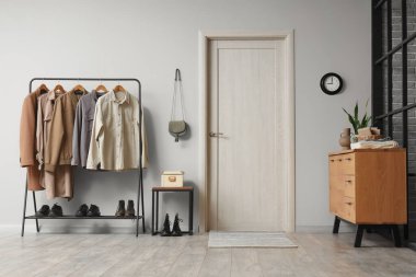 Bej kapılı, çekmeceli ve gri duvarlı giysileri olan modern salonun içi.