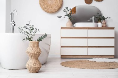 Banyonun içinde küvet ve çekmeceler beyaz duvarın yanında.