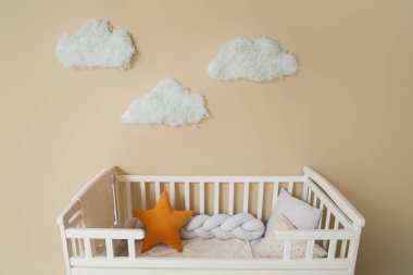 Bej duvardaki bebek beşiği ve bulutlar