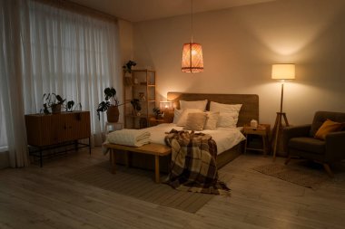 Gecenin geç saatlerinde parlayan lambaları olan şık bir yatak odası.