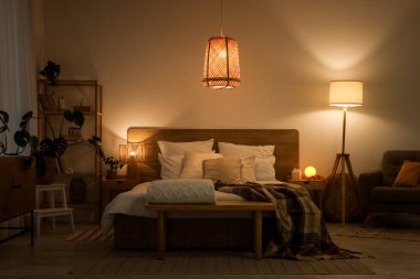 Gecenin geç saatlerinde parlayan lambaları olan şık bir yatak odası.