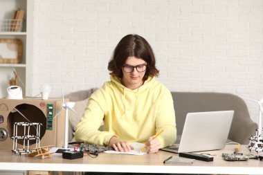 Erkek mucit evde çizim yapıyor.