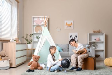 Evinde macera kitabı okuyan sevimli çocuklar.