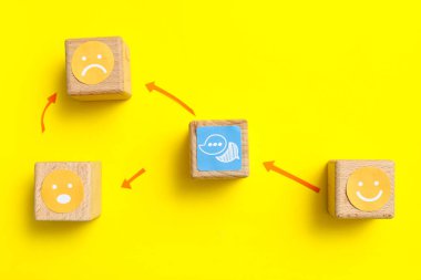 Gülücüklerle ve sarı arka planda konuşma baloncuklarıyla bağlı küplerle. Bağlantı konsepti