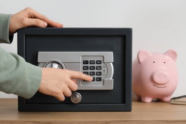 Işık duvarının yanındaki rafta kasa açan kadın, yakın plan.