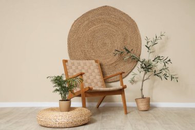 Hasır sandalye, ev bitkisi ve hasır dekoru bej duvarda.