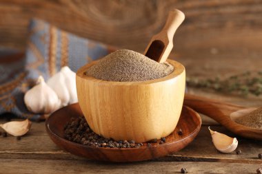 Karabiber tozu, sarımsak ve ahşap zemin üzerinde biber dolu bir kâse.