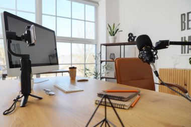 Ofisinde bilgisayar ve mikrofon bulunan blogcu işyeri, kapat