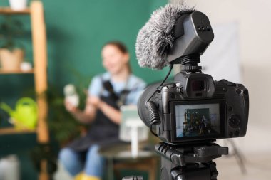 Stüdyodaki kamera ekranında bitki kayıt videosu olan kadın blogcu, yakın plan